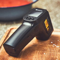 Image 39653653184808 Infraroodthermometer met bedieningsknoppen ligt op snijplank