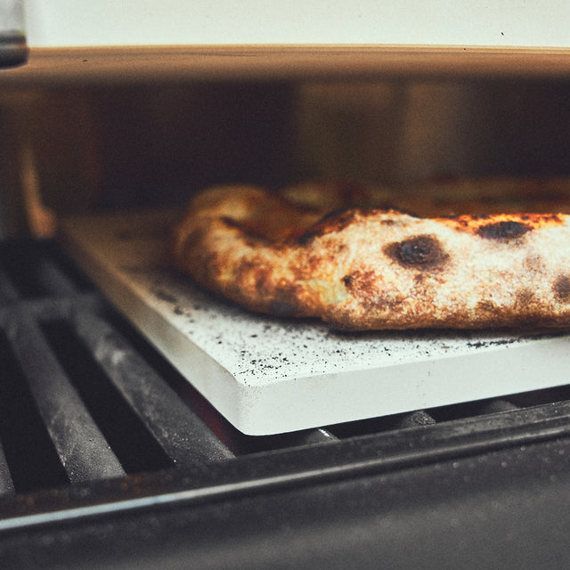 Detail pizzasteen op een grillrooster